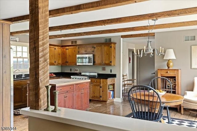 153 Lambertville Hq Rd, Delaware Twp, NJ 08559 - kitchen featuring stainless steel microwave, stove, brown cabinetry, a chandelier, and beamed ceiling