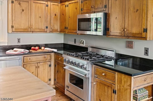 153 Lambertville Hq Rd, Delaware Twp, NJ 08559 - kitchen featuring appliances with stainless steel finishes, light wood finished floors, brown cabinetry, and dark countertops