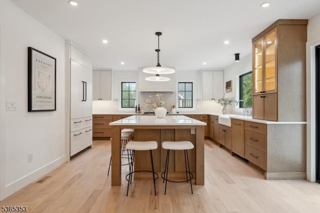 338 Old Short Hills Rd, Millburn Twp, NJ 07078 - kitchen featuring a breakfast bar, decorative backsplash, a center island, light wood-style flooring, and recessed lighting