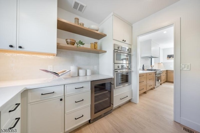 338 Old Short Hills Rd, Millburn Twp, NJ 07078 - kitchen with beverage cooler, appliances with stainless steel finishes, light wood-type flooring, tasteful backsplash, and light countertops
