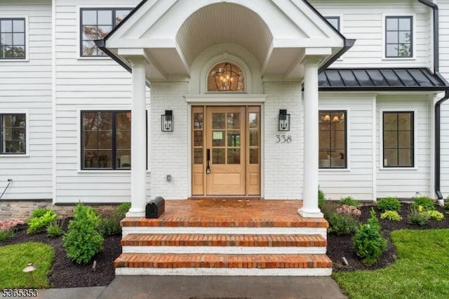 338 Old Short Hills Rd, Millburn Twp, NJ 07078 - property entrance with a standing seam roof, brick siding, a porch, and a metal roof