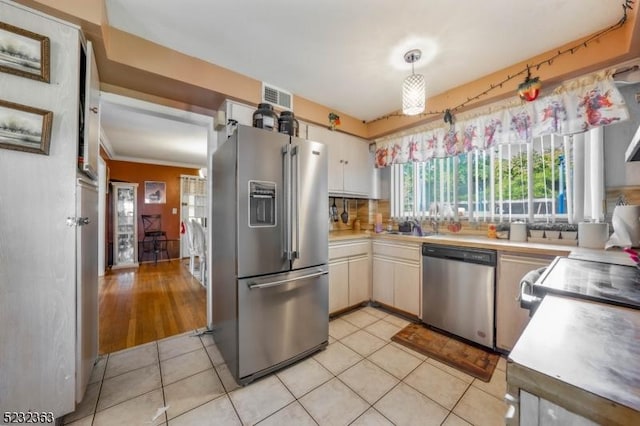 340 Hamilton St, Roselle Boro, NJ 07203 - kitchen with stainless steel appliances, light tile patterned flooring, light countertops, white cabinets, and backsplash