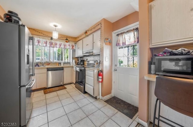 340 Hamilton St, Roselle Boro, NJ 07203 - kitchen featuring appliances with stainless steel finishes, light countertops, light tile patterned floors, under cabinet range hood, and white cabinets