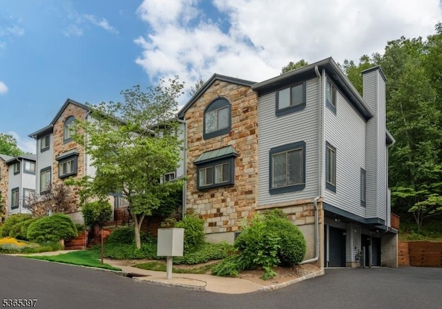 46 Overlook Dr Unit 46, Independence Twp, NJ 07840 - view of front of home featuring stone siding, a chimney, and asphalt driveway