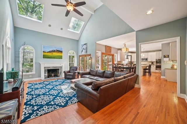 4 Knollwood Ter, Chester Twp, NJ 07930 - living room with high vaulted ceiling, ceiling fan, light wood-type flooring, a skylight, and a high end fireplace