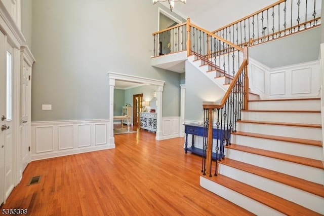 4 Knollwood Ter, Chester Twp, NJ 07930 - entryway featuring a towering ceiling, stairs, wood finished floors, wainscoting, and a decorative wall