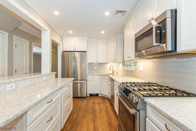 9 Hilary Ct, Vernon Twp, NJ 07460 - kitchen with appliances with stainless steel finishes, white cabinets, tasteful backsplash, wood finished floors, and light stone countertops