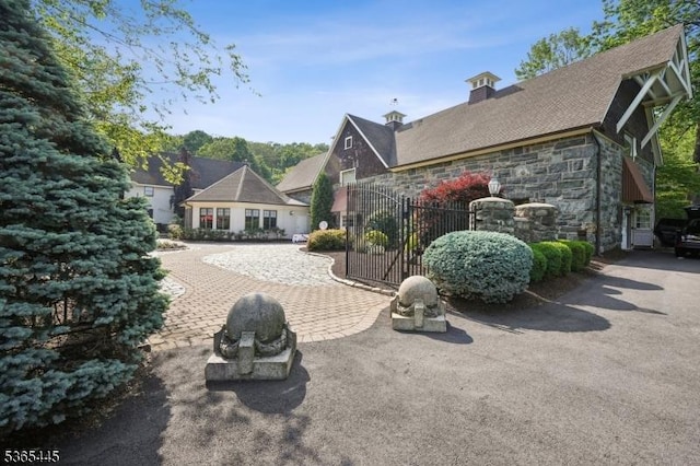 8 Hornbeam Ln, Kinnelon Boro, NJ 07405 - back of house with stone siding, a chimney, and a gate