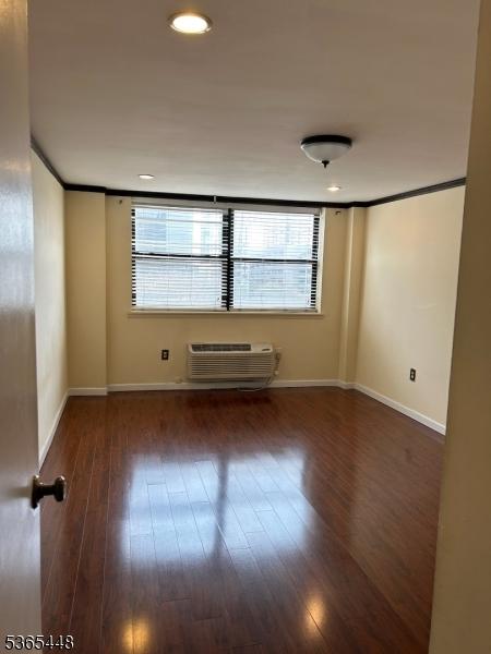111 Mulberry St Unit 4R, Newark City, NJ 07102 - empty room with a wall mounted AC and hardwood / wood-style flooring