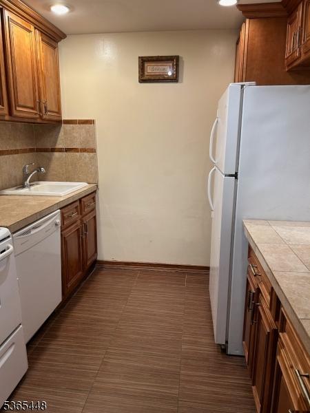 111 Mulberry St Unit 4R, Newark City, NJ 07102 - kitchen with white appliances, brown cabinets, and backsplash