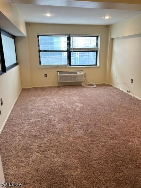111 Mulberry St Unit 4R, Newark City, NJ 07102 - spare room with an AC wall unit, healthy amount of natural light, and carpet