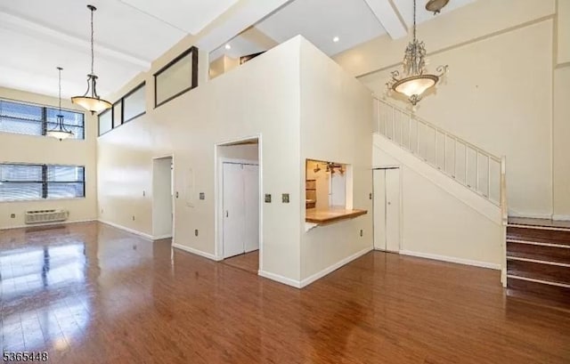 111 Mulberry St Unit 4R, Newark City, NJ 07102 - unfurnished living room featuring wood finished floors, a towering ceiling, stairway, beam ceiling, and a wall unit AC