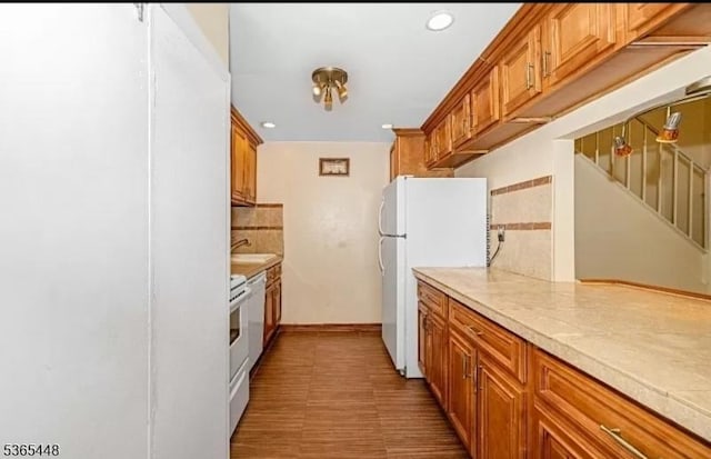 111 Mulberry St Unit 4R, Newark City, NJ 07102 - kitchen featuring freestanding refrigerator, light countertops, brown cabinetry, recessed lighting, and stove