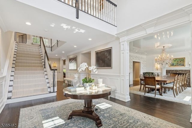 119 Mosle Rd, Mendham Twp, NJ 07945 - foyer entrance featuring a decorative wall, wood finished floors, crown molding, stairway, and a chandelier