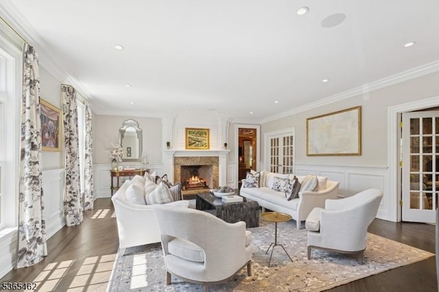 119 Mosle Rd, Mendham Twp, NJ 07945 - living area featuring a decorative wall, crown molding, wood finished floors, a warm lit fireplace, and wainscoting