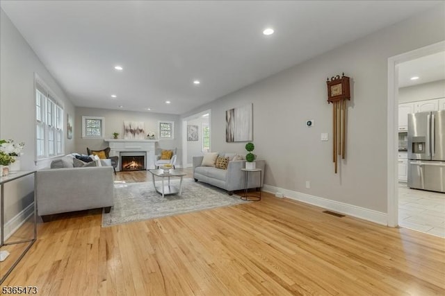 162 N Maple Ave, Bernards Twp, NJ 07920 - living area with light wood finished floors, healthy amount of natural light, a warm lit fireplace, and recessed lighting