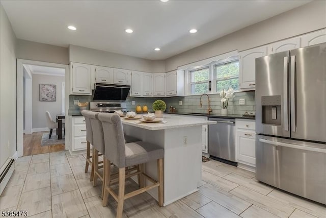 162 N Maple Ave, Bernards Twp, NJ 07920 - kitchen with stainless steel appliances, white cabinets, decorative backsplash, a breakfast bar area, and recessed lighting