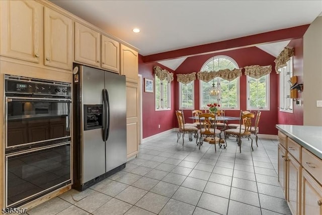 33 Gates Pl, Wayne Twp, NJ 07470 - kitchen with stainless steel fridge, lofted ceiling, light brown cabinetry, light tile patterned floors, and light countertops
