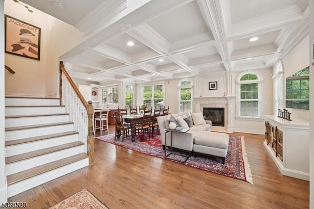 27 Green Way, New Providence Boro, NJ 07974 - living room featuring light wood-style flooring, coffered ceiling, stairway, beamed ceiling, and a glass covered fireplace