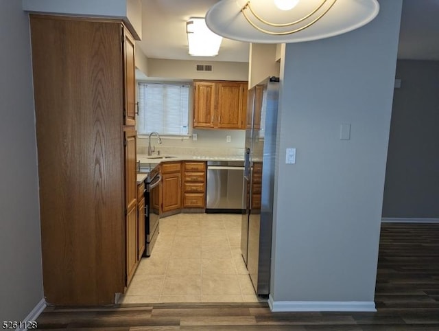 15 Ray Ct, Bedminster Twp, NJ 07921 - kitchen with appliances with stainless steel finishes, light countertops, brown cabinetry, and light wood-type flooring