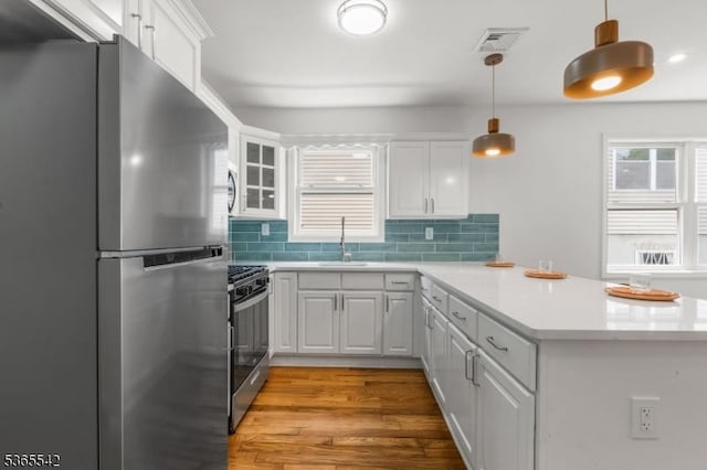 98 S Burnett St, East Orange City, NJ 07018 - kitchen with appliances with stainless steel finishes, a peninsula, white cabinetry, light countertops, and light wood finished floors