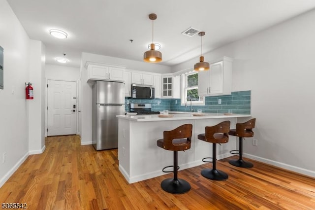 98 S Burnett St, East Orange City, NJ 07018 - kitchen featuring stainless steel appliances, a peninsula, tasteful backsplash, and white cabinets
