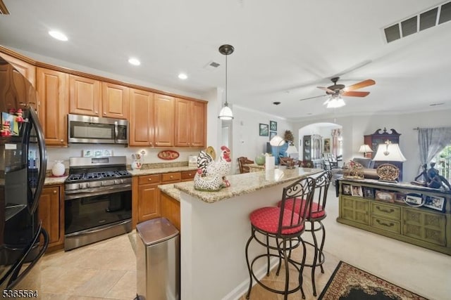 63 Ridgeview Ln, Mount Arlington Boro, NJ 07856 - kitchen featuring appliances with stainless steel finishes, open floor plan, a breakfast bar, light stone counters, and a ceiling fan
