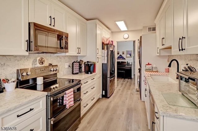 2 Claridge Dr Unit 7Lw, Verona Twp, NJ 07044 - kitchen featuring range with two ovens, freestanding refrigerator, white cabinets, light wood-style flooring, and backsplash