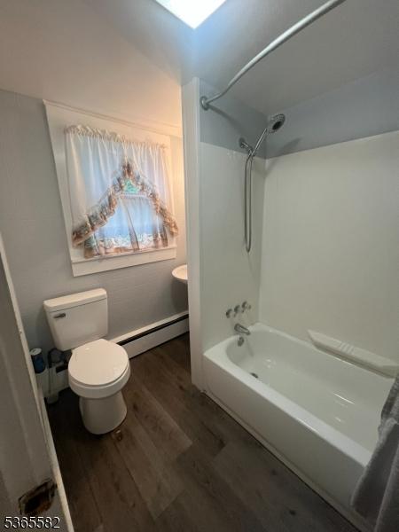 15 Fisk St, Belvidere Twp, NJ 07823 - bathroom with a baseboard heating unit, wood finished floors, and bathtub / shower combination