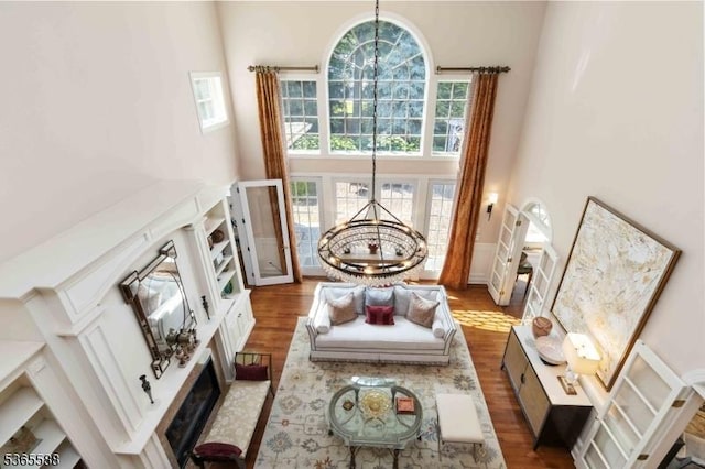 10 Westminster Pl, Morris Twp, NJ 07960 - living room featuring a towering ceiling, a chandelier, plenty of natural light, wood finished floors, and a wainscoted wall