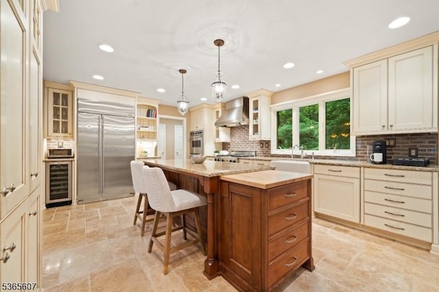 10 Kilmer Dr, Hillsborough Twp, NJ 08844 - kitchen with stainless steel appliances, wall chimney exhaust hood, beverage cooler, cream cabinetry, and recessed lighting