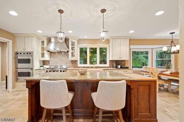 10 Kilmer Dr, Hillsborough Twp, NJ 08844 - kitchen with appliances with stainless steel finishes, wall chimney exhaust hood, a kitchen island, tasteful backsplash, and recessed lighting
