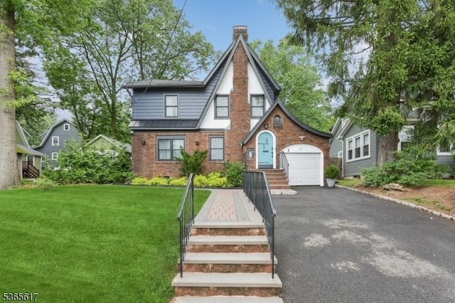 17 Lowell Ave, West Orange Twp, NJ 07052 - tudor house with asphalt driveway, brick siding, a chimney, a front lawn, and an attached garage