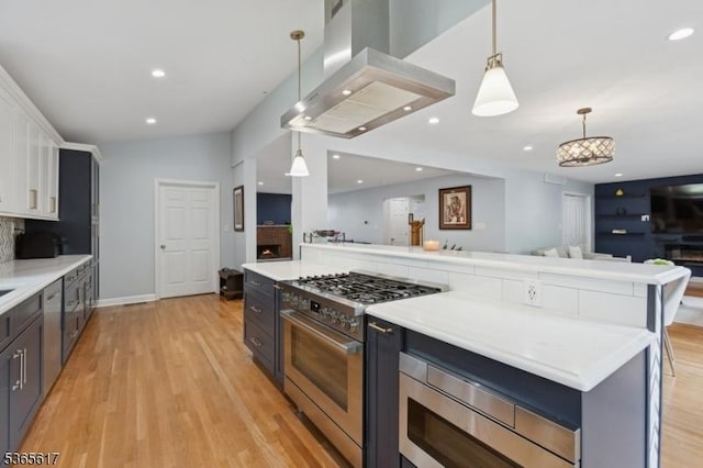 17 Lowell Ave, West Orange Twp, NJ 07052 - kitchen featuring appliances with stainless steel finishes, extractor fan, open floor plan, white cabinets, and light wood-style flooring