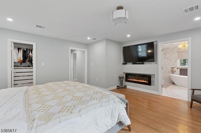 17 Lowell Ave, West Orange Twp, NJ 07052 - bedroom featuring wood finished floors, recessed lighting, a glass covered fireplace, connected bathroom, and a walk in closet