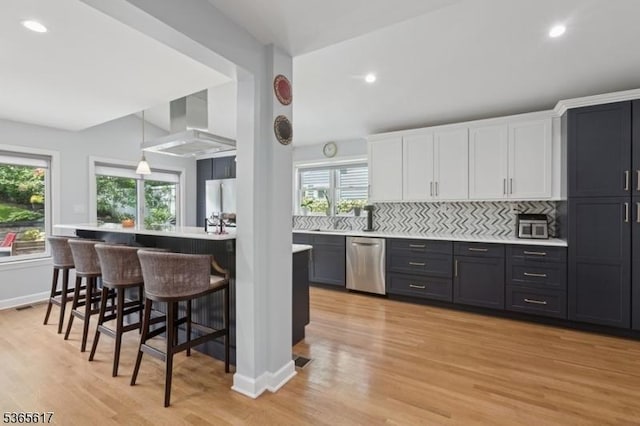 17 Lowell Ave, West Orange Twp, NJ 07052 - kitchen with dishwasher, a kitchen breakfast bar, white cabinets, backsplash, and light wood-type flooring