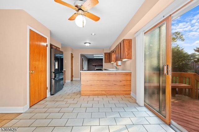 1265 Iris St, North Brunswick Twp, NJ 08902 - kitchen featuring freestanding refrigerator, brown cabinets, a peninsula, light countertops, and light tile patterned floors