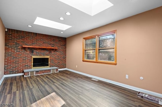 1265 Iris St, North Brunswick Twp, NJ 08902 - unfurnished living room featuring a skylight, wood finished floors, a brick fireplace, and recessed lighting