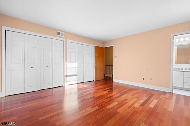 1265 Iris St, North Brunswick Twp, NJ 08902 - unfurnished bedroom with two closets, wood finished floors, and connected bathroom