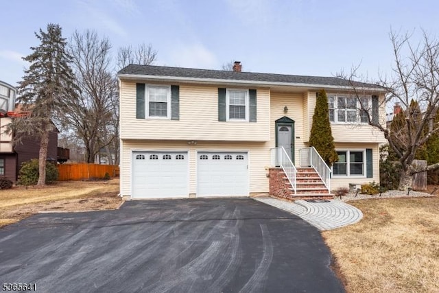 9 Village Ct, Flemington Boro, NJ 08822 - bi-level home featuring asphalt driveway, a chimney, and an attached garage