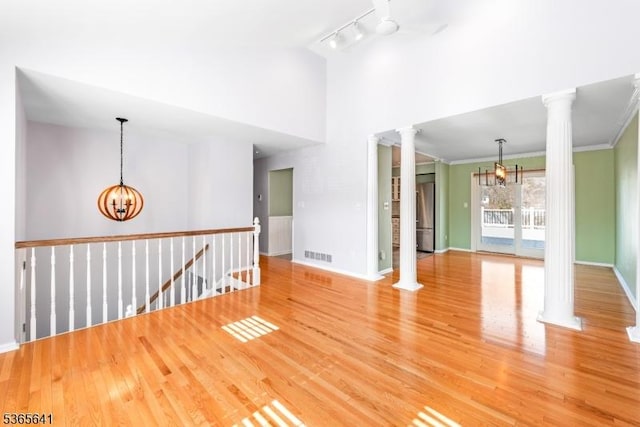 9 Village Ct, Flemington Boro, NJ 08822 - unfurnished room with ornate columns, a chandelier, light wood finished floors, a high ceiling, and crown molding