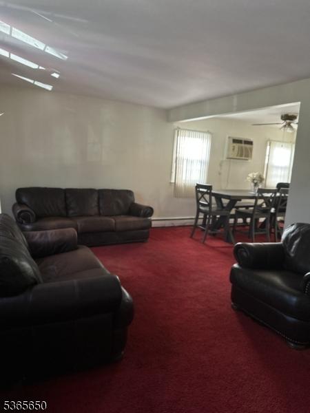 73 Berkeley Ter, Irvington Twp, NJ 07111 - living area with carpet flooring, an AC wall unit, and a ceiling fan
