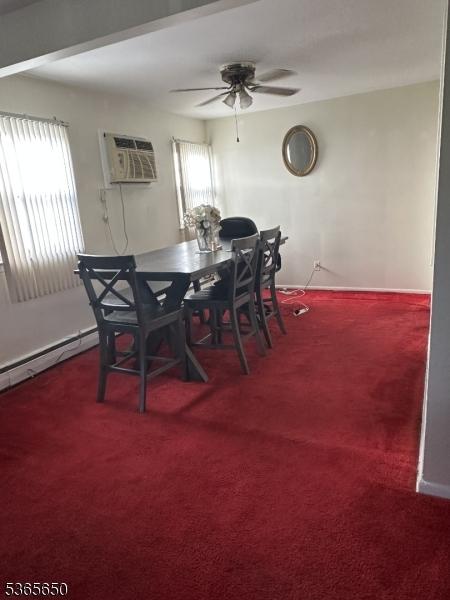 73 Berkeley Ter, Irvington Twp, NJ 07111 - dining room featuring ceiling fan, carpet floors, a wall mounted air conditioner, and a baseboard heating unit