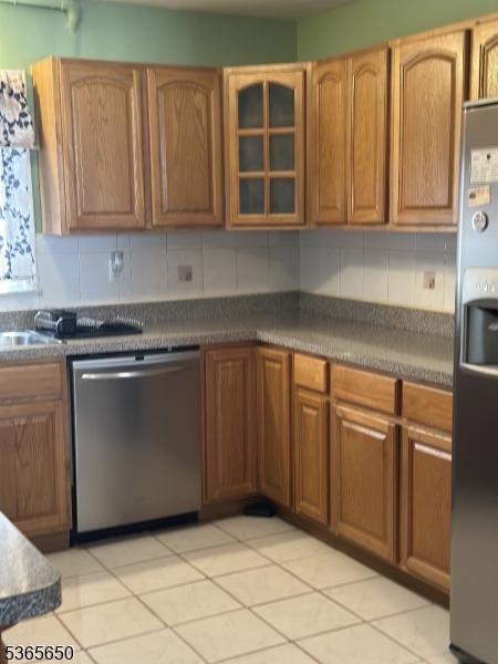 73 Berkeley Ter, Irvington Twp, NJ 07111 - kitchen with appliances with stainless steel finishes, glass insert cabinets, tasteful backsplash, and light tile patterned flooring