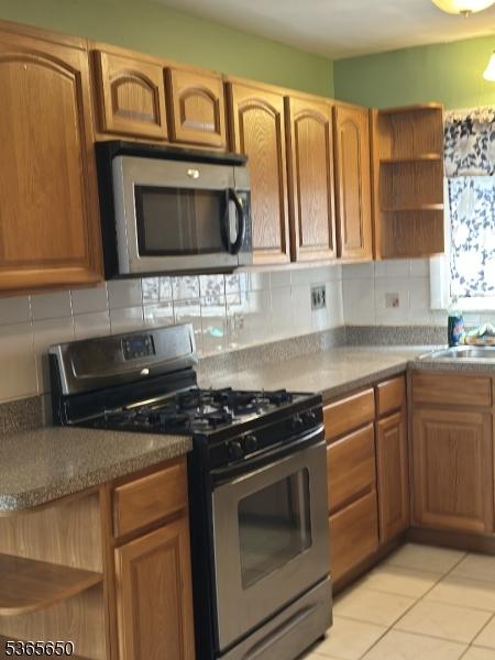 73 Berkeley Ter, Irvington Twp, NJ 07111 - kitchen featuring appliances with stainless steel finishes, open shelves, and decorative backsplash
