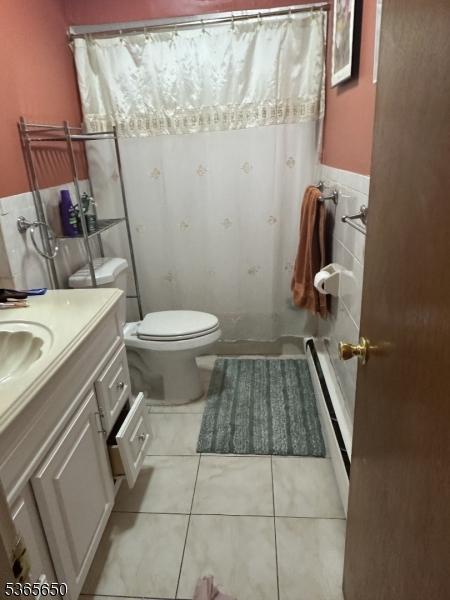 73 Berkeley Ter, Irvington Twp, NJ 07111 - full bath with vanity, tile patterned floors, curtained shower, a wainscoted wall, and tile walls