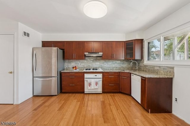 922C Merritt Dr, Hillsborough Twp, NJ 08844 - kitchen with white appliances, under cabinet range hood, light wood finished floors, backsplash, and light stone counters