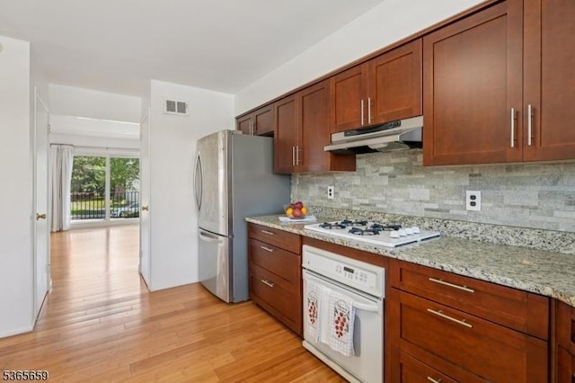 922C Merritt Dr, Hillsborough Twp, NJ 08844 - kitchen with under cabinet range hood, white appliances, light wood finished floors, tasteful backsplash, and light stone counters