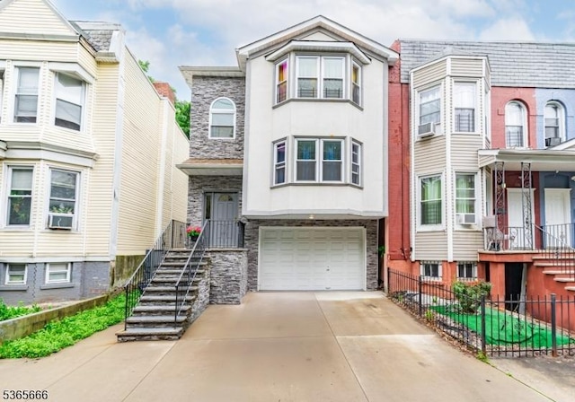 112-114 N 13th St, Newark City, NJ 07107 - view of property featuring stone siding, driveway, a garage, and stairway