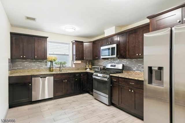 112-114 N 13th St, Newark City, NJ 07107 - kitchen with stainless steel appliances, backsplash, dark brown cabinets, light stone counters, and light wood-style flooring